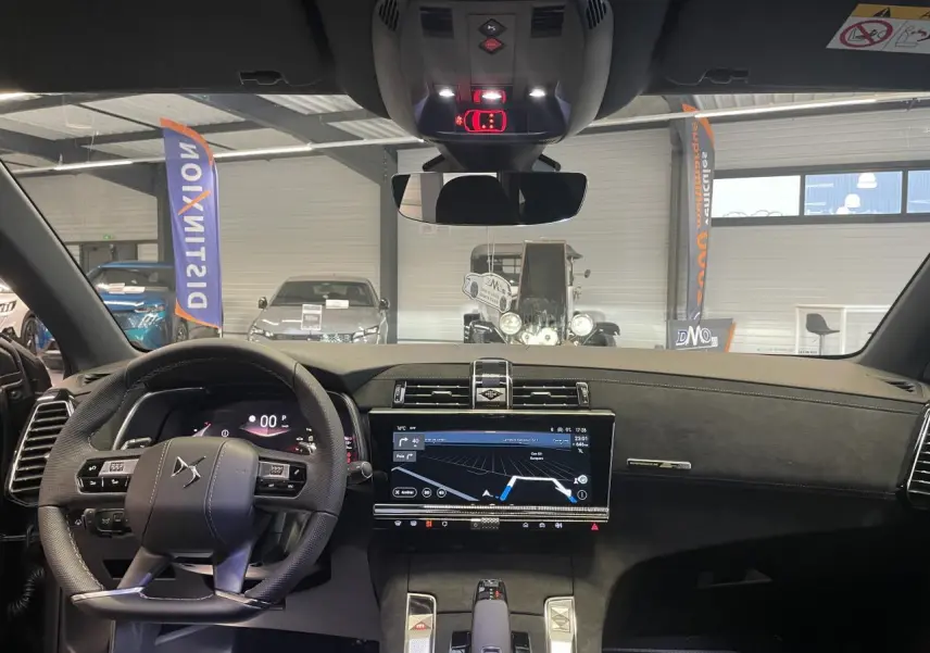 Vue intérieure avant du DS7 Crossback gris titanium, volant cuir perforé et écran tactile 12 pouces avec navigation affichée.