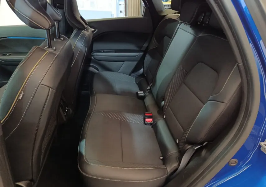 Vue intérieure côté droit des sièges arrière noirs du Renault Symbioz bleu, soulignant la finition et les surpiqûres.