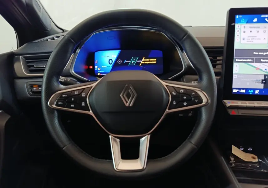 Vue centrée sur le volant noir du Renault SYMBIOZ 2025 avec tableau de bord numérique et écran tactile latéral.