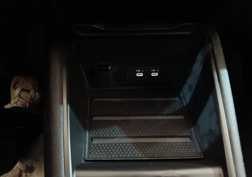 Gros plan sur la console centrale noire du Renault Symbioz bleu, montrant deux ports USB éclairés.