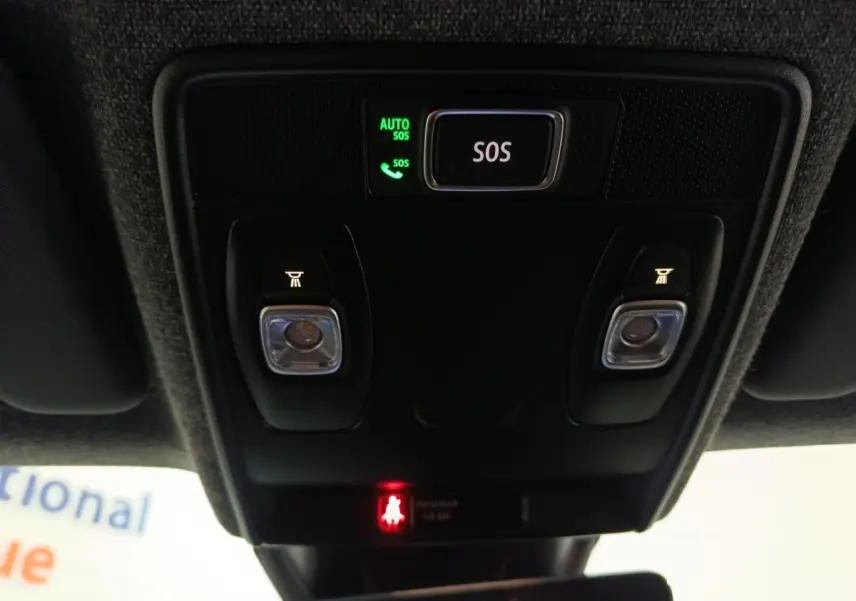 Vue en contre-plongée du panneau de commande au plafond avec bouton SOS éclairé dans un Renault Symbioz bleu.