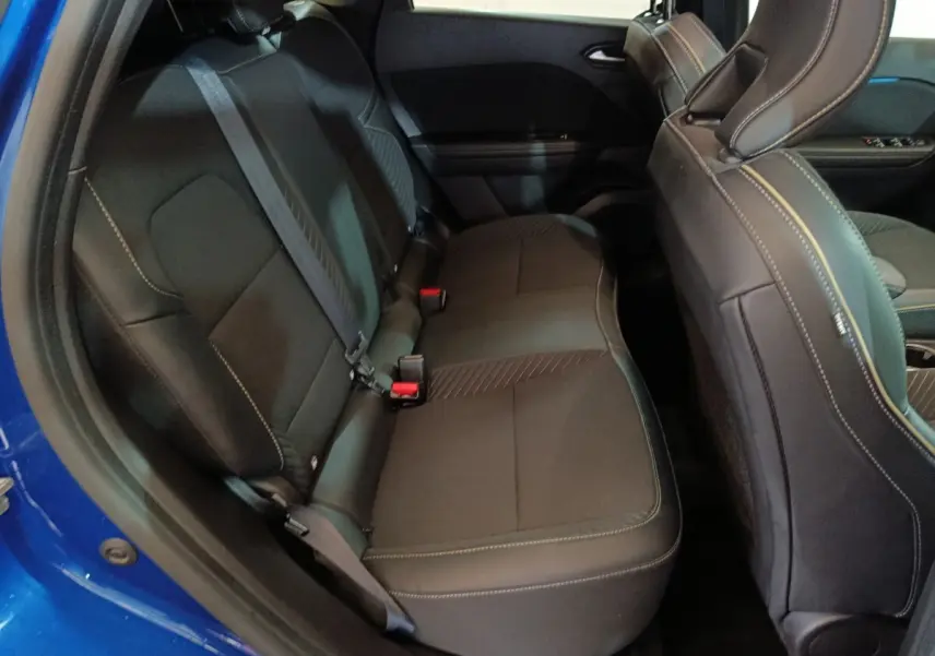 Vue côté gauche sur la banquette arrière noire du Renault SYMBIOZ bleu, avec ceinture de sécurité et détails de couture visibles.