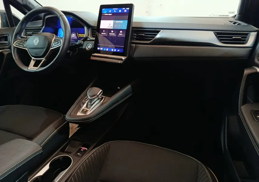 Vue intérieure côté conducteur du tableau de bord noir du Renault Symbioz avec écran tactile vertical et volant multifonctions.