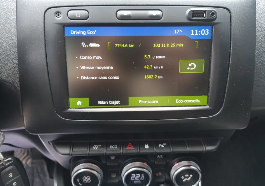 Écran central tactile du tableau de bord du Dacia Duster gris 2020 affichant les données de consommation et de trajet.