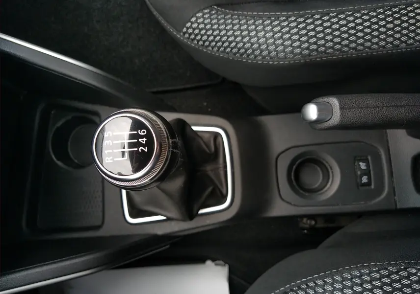 Vue rapprochée du levier de vitesses manuel et frein à main du Dacia Duster 2020, intérieur tissu noir à motifs.