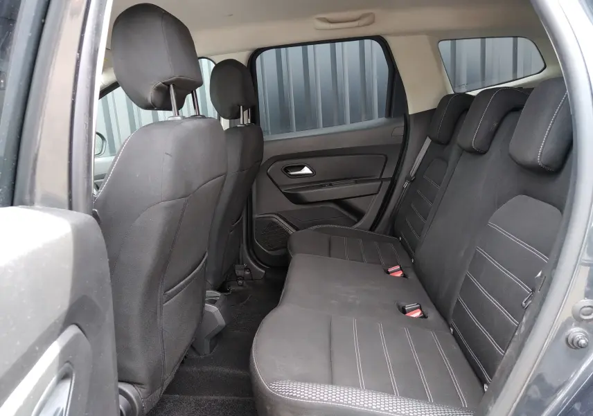 Vue intérieure côté droit montrant la banquette arrière noire du Dacia Duster 2020 gris, finition Prestige.