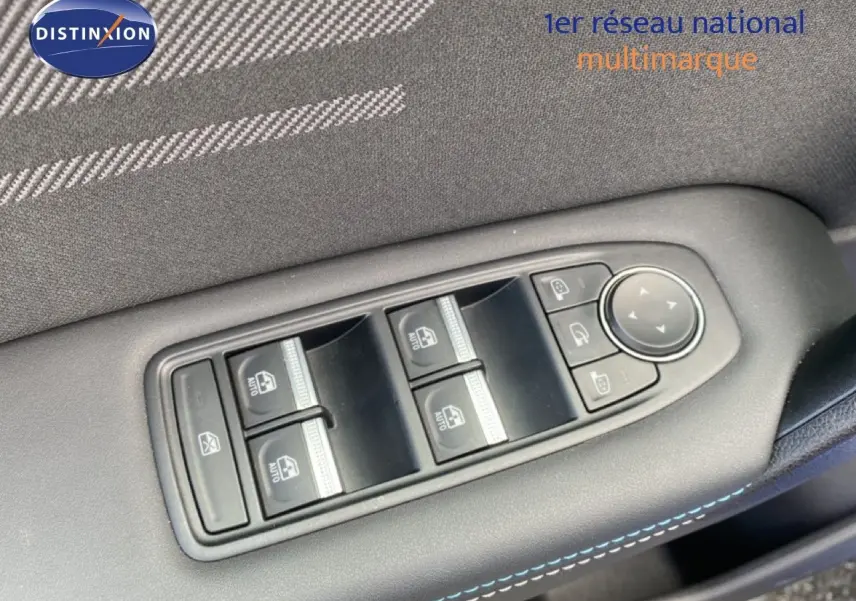 Gros plan sur les commandes de lève-vitres et rétroviseurs côté conducteur d’une Renault Symbioz bleu Iron Metal.