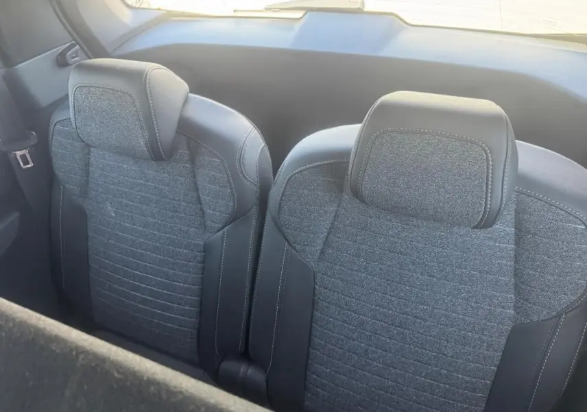 Vue rapprochée des sièges arrière gris en tissu et cuir du Peugeot 5008 Hybrid 2025, version Allure.