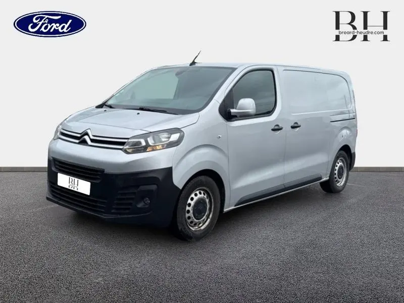 Vue 3/4 avant droit d'un Citroën Jumpy gris aluminium avec double portes latérales et pare-chocs noirs.