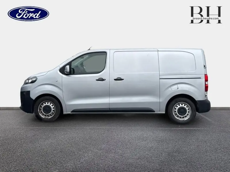 Vue de profil côté gauche d'un utilitaire Citroën Jumpy gris aluminium, avec portes latérales et roues acier.