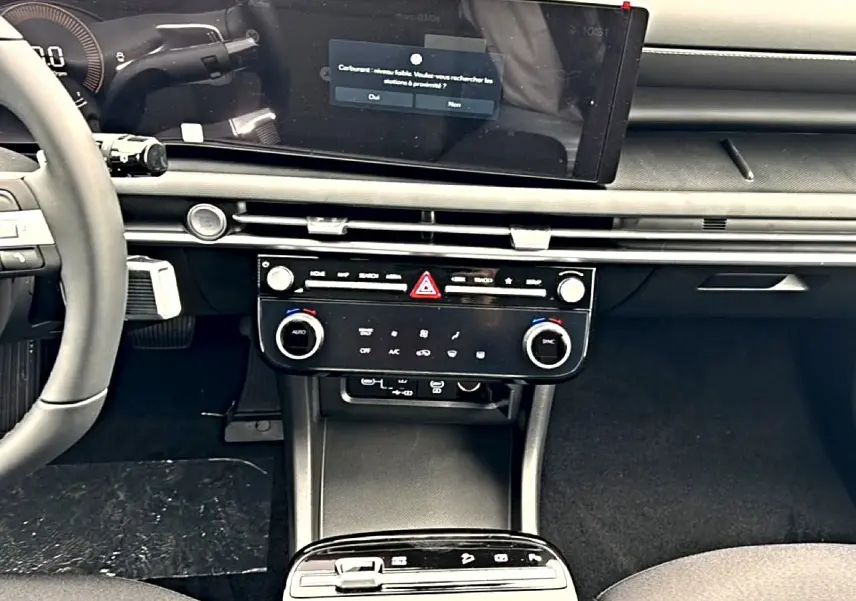 Vue intérieure du tableau de bord du Hyundai Tucson 2026, écran tactile large et commandes climatisation modernes.