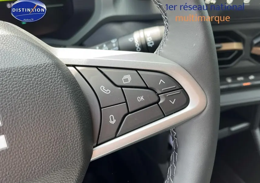 Gros plan sur les commandes multifonctions à droite du volant du Dacia Duster noir 2025, intérieur moderne.