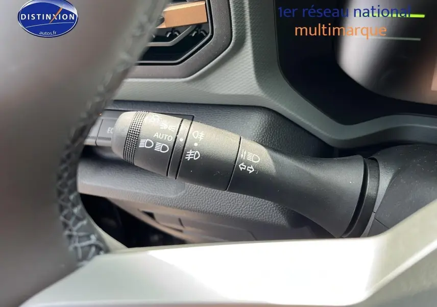 Gros plan sur la commande des phares et clignotants du tableau de bord du Dacia Duster noir 2025.