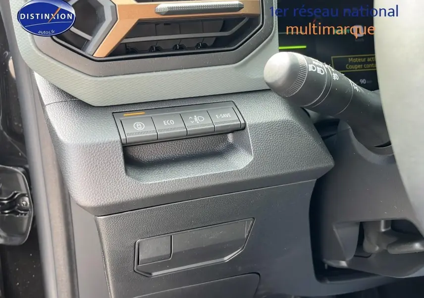 Détail du tableau de bord noir du Dacia Duster 2025 avec commandes eco, e-save et régulateur de phares.