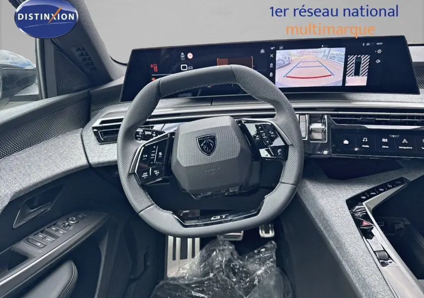 Vue intérieure centrée sur le volant cuir noir et le tableau de bord numérique du Peugeot 3008 Hybrid GT 2025.