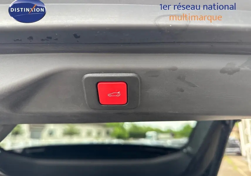 Bouton rouge d'ouverture électrique du hayon sur Peugeot 3008 noir perle métal, vue intérieure arrière du coffre.