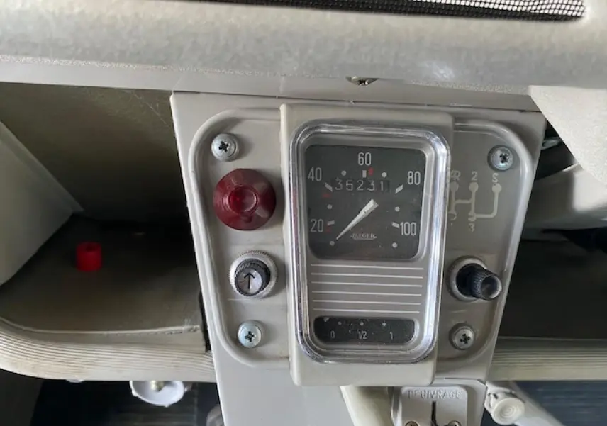 Gros plan sur le compteur de vitesse beige clair d'une Citroën 2 CV 1968 refaite à neuf, avec indicateur manuel de vitesses.
