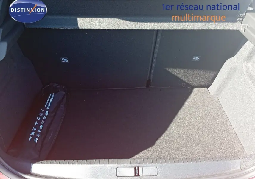 Coffre ouvert d'une Opel Corsa rouge Kardio métal avec toit noir, vue plongeante sur l'espace de chargement vide.