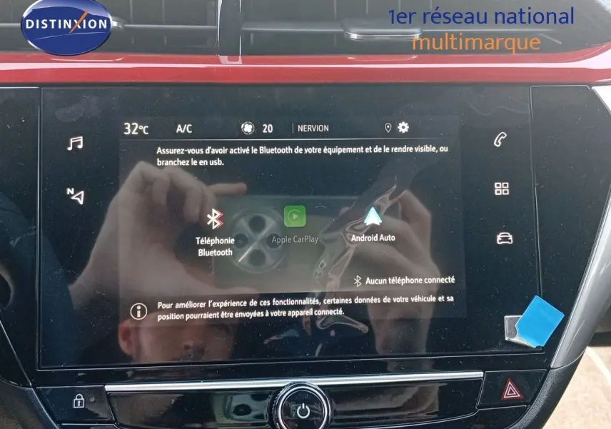 Écran tactile central de la console d'une Opel Corsa rouge Kardio Métal avec toit noir, affichant options Bluetooth et Android Auto.
