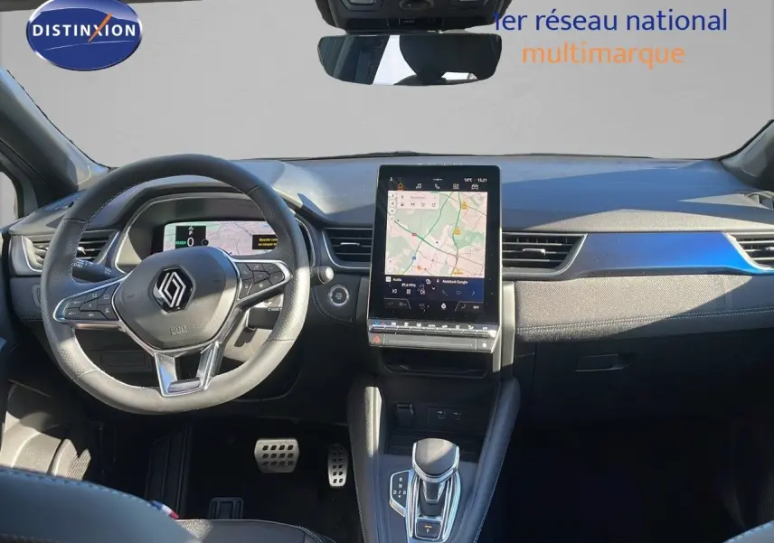 Vue intérieure avant du Renault Captur E-Tech hybride 2025, tableau de bord moderne avec écran tactile central et volant multifonction.