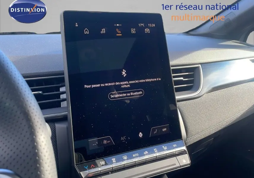 Écran tactile central allumé dans l'habitacle du Renault Captur E-Tech gris rafale métal avec toit noir, vue côté droit.