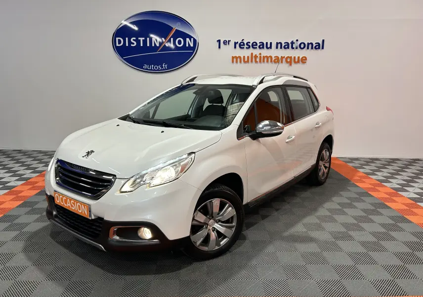 Peugeot 2008 blanc vue 3/4 avant droit avec phares et antibrouillards allumés en showroom.