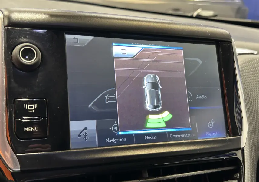 Écran central de la Peugeot 2008 blanc montrant l'affichage du radar de recul avec signalisation verte.