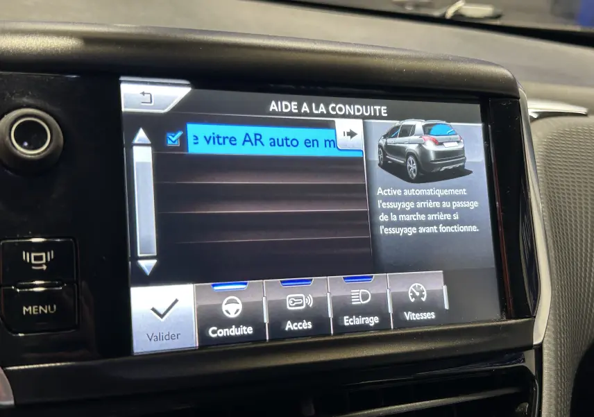 Écran tactile intérieur du Peugeot 2008 blanc de 2014 montrant le menu d’aide à la conduite avec illustration du véhicule en 3/4 arrière.