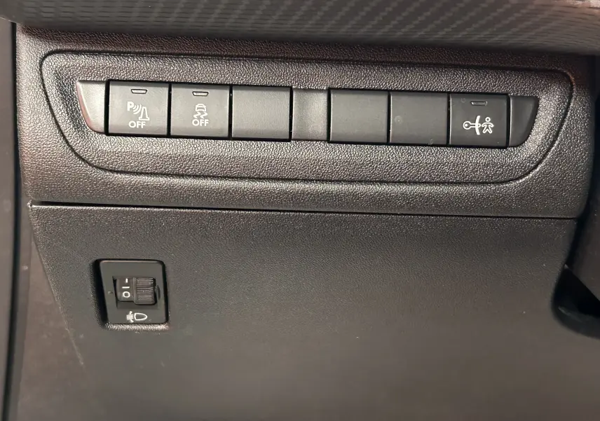 Gros plan sur les boutons de commande du tableau de bord côté conducteur du Peugeot 2008 blanc VTi 82 Allure 2014.