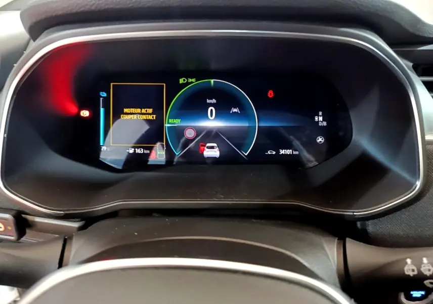 Vue rapprochée du combiné d'instruments numérique de la Renault ZOE Business R110 blanc, affichant 0 km/h et alertes moteur.