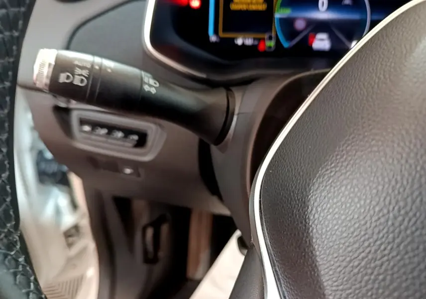 Gros plan sur le volant cuir noir et la commande des phares de la Renault ZOE Business R110 2021.