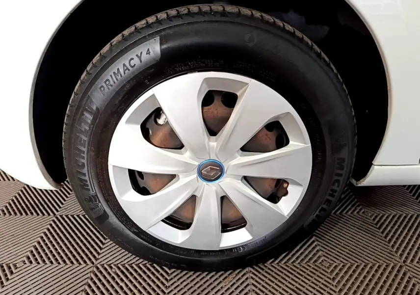 Gros plan sur la roue avant gauche blanche d'une Renault ZOE Business R110 avec jante et logo Renault au centre.