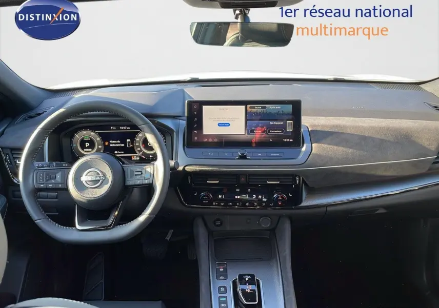 Vue intérieure avant du Nissan Qashqai 2025, tableau de bord moderne avec écran central et volant multifonction noir.