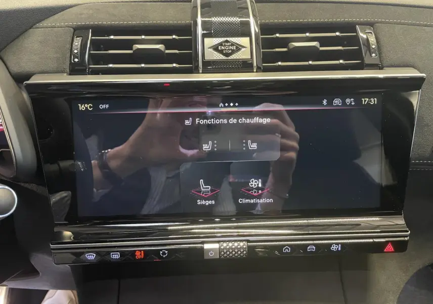 Écran tactile central du DS7 Crossback gris titanium, affichant les fonctions de chauffage, entouré d'inserts noirs brillants et Alcantara noir.