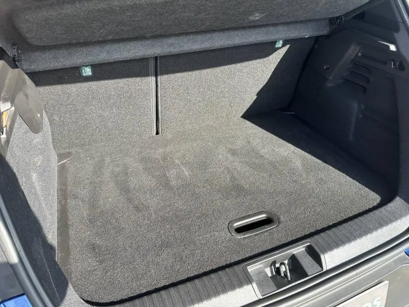 Coffre ouvert du Renault Captur 2025 Bleu Iron/Noir Etoilé, vue plongeante sur l’espace de rangement vide et propre.