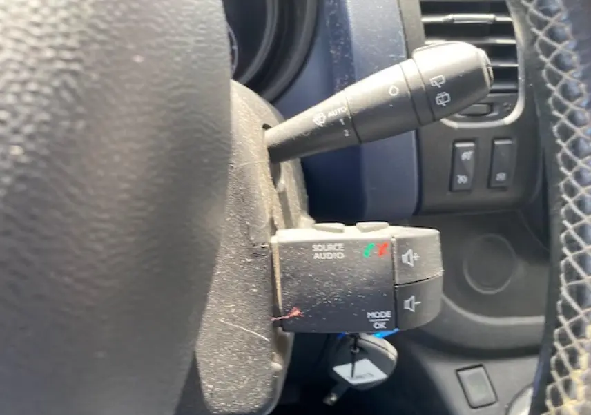 Gros plan sur la commande audio au volant et le commodo d’essuie-glace dans l’habitacle d’un Opel Vivaro blanc 2018.