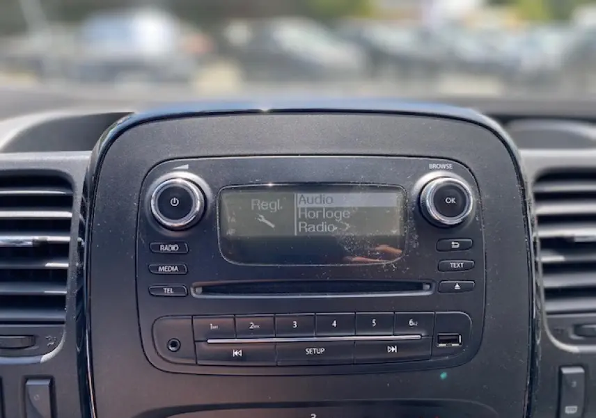 Tableau de bord noir de l'Opel Vivaro 2018 avec écran radio et commandes audio visibles en gros plan.