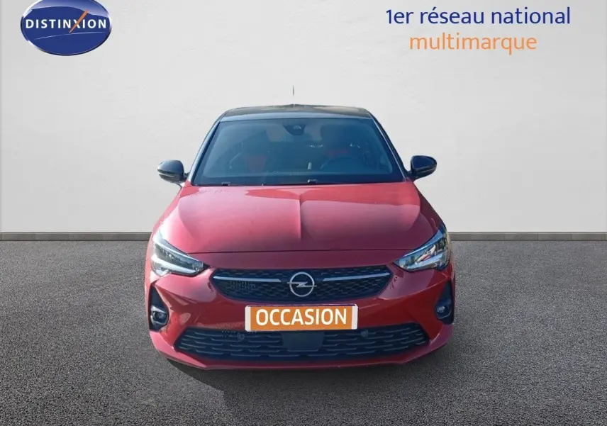 Vue frontale d'une Opel Corsa 2023 rouge Kardio métal avec toit noir, affichant sa calandre et phares LED.