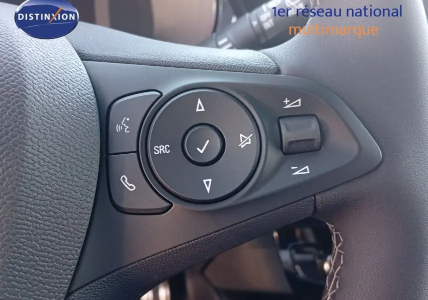 Gros plan sur les commandes audio et téléphone au volant d'une Opel Corsa 2023, intérieur noir.