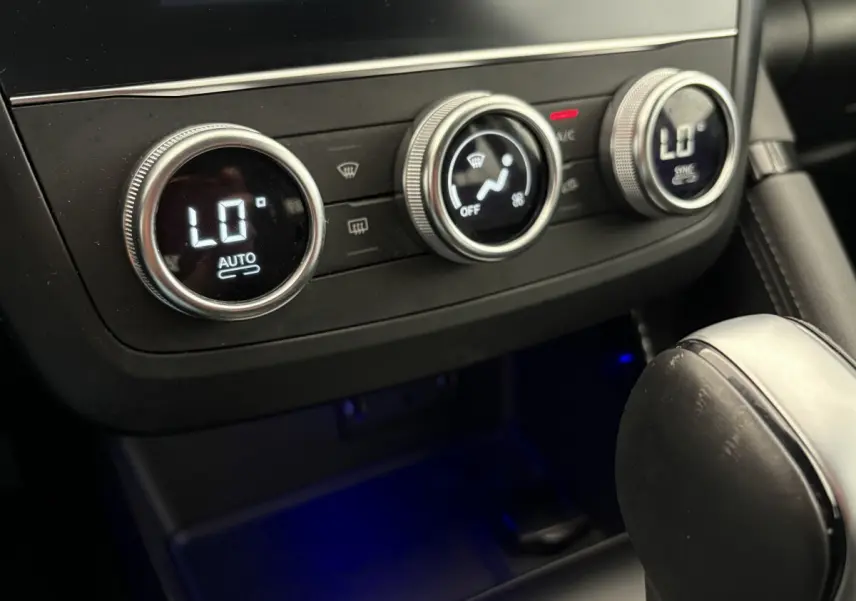 Détail de la commande de climatisation digitale avec réglages circulaires dans le Renault Kadjar gris foncé, vue intérieure rapprochée.