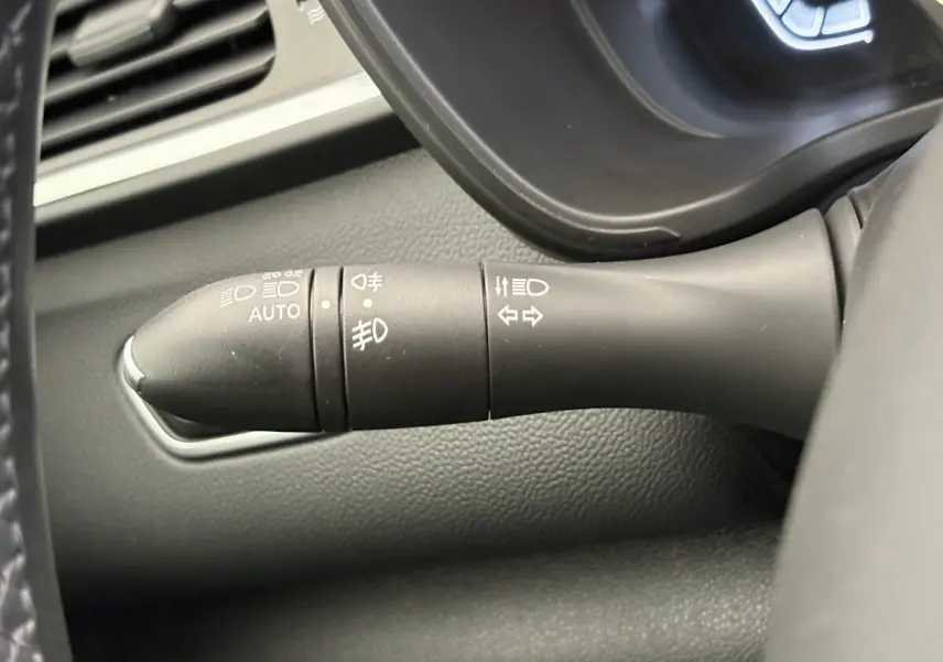 Gros plan sur la commande des phares et clignotants du Renault Kadjar gris foncé, intérieur tableau de bord.