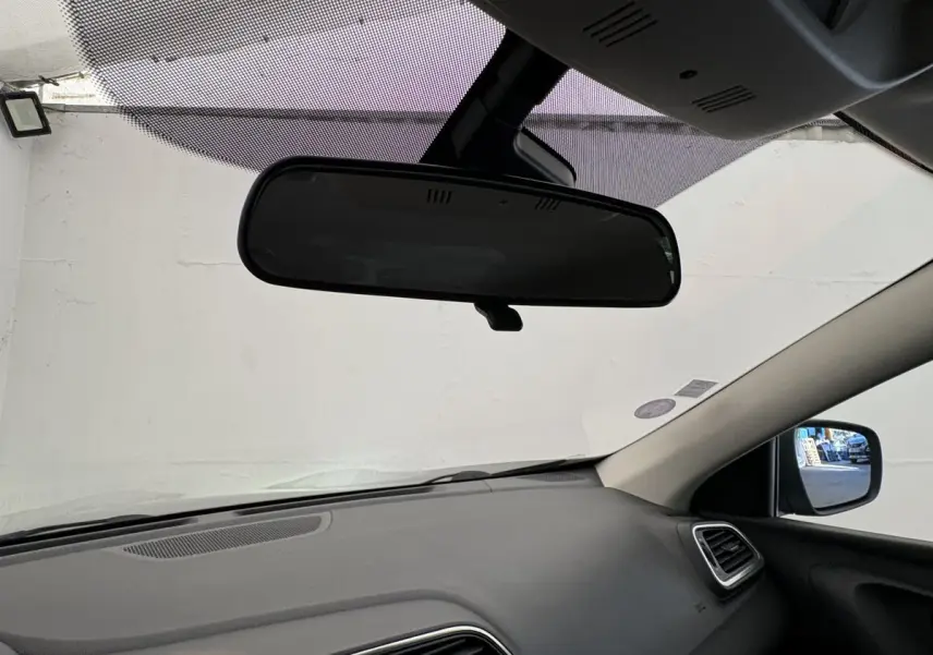 Vue intérieure du tableau de bord et rétroviseur central du Renault Kadjar gris foncé, côté passager visible.