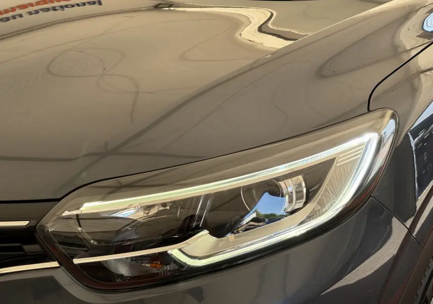 Gros plan sur le phare avant droit du Renault Kadjar gris foncé, mettant en valeur ses feux LED modernes.