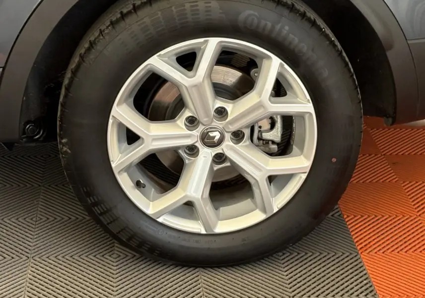 Gros plan sur la roue avant droite du Renault Kadjar gris foncé, mettant en valeur la jante alliage au design moderne.