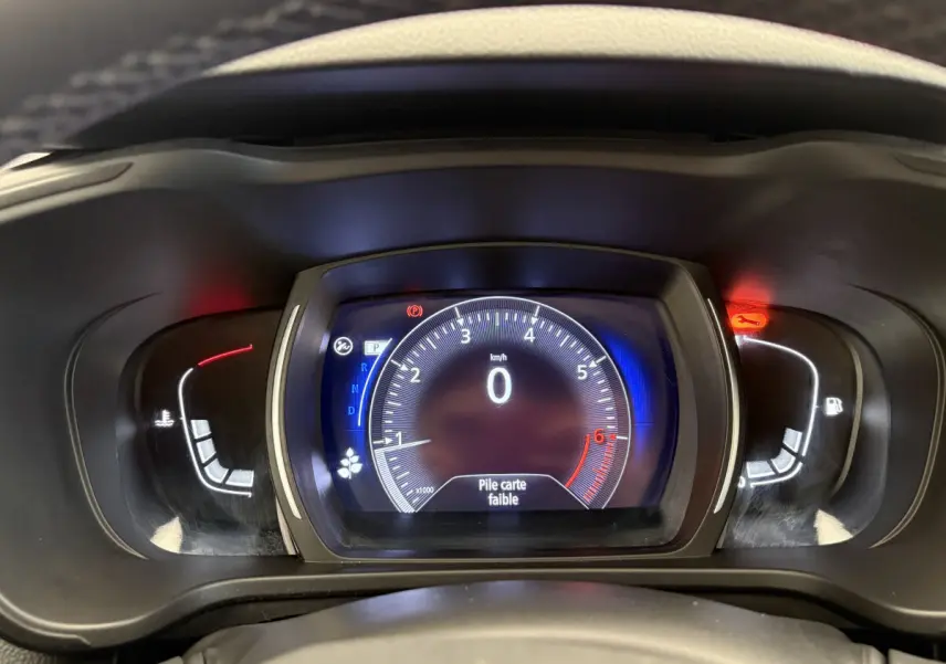 Vue rapprochée du tableau de bord numérique du Renault Kadjar 2019 affichant le compteur et un message "Pile carte faible".