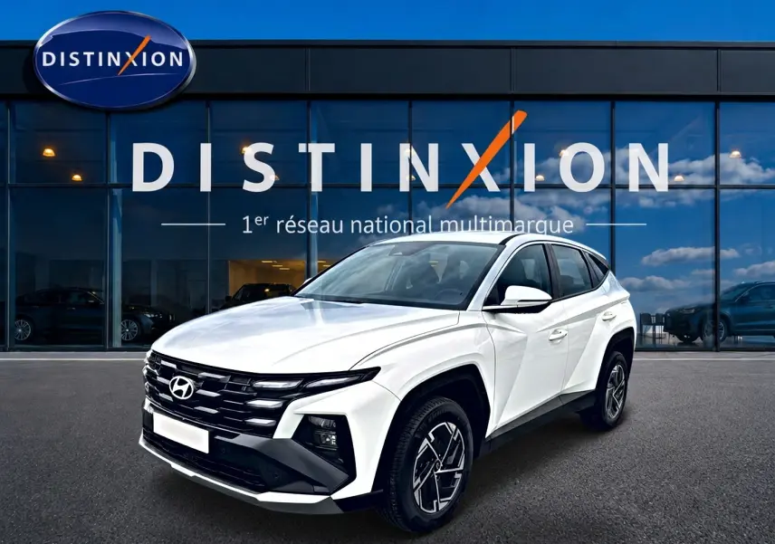 Hyundai Tucson blanc 2026 en 3/4 avant droit, avec calandre noire et jantes alliage 17 pouces visibles.