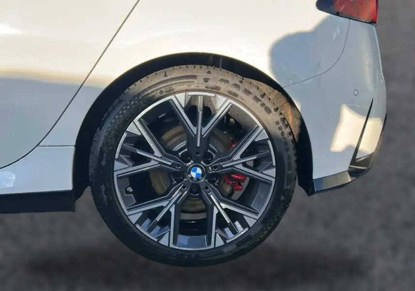 Gros plan sur la jante arrière droite bicolore en Y de la BMW Série 1 blanche alpine avec étrier de frein rouge visible.
