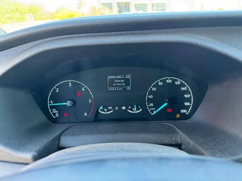 Vue rapprochée du tableau de bord du Ford Transit Fourgon blanc, affichant compteurs et écran digital allumé