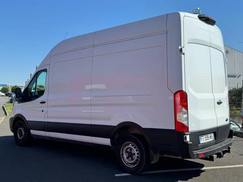 Ford Transit Fourgon blanc glacier vu en 3/4 arrière droit, avec portes battantes et porte latérale coulissante.