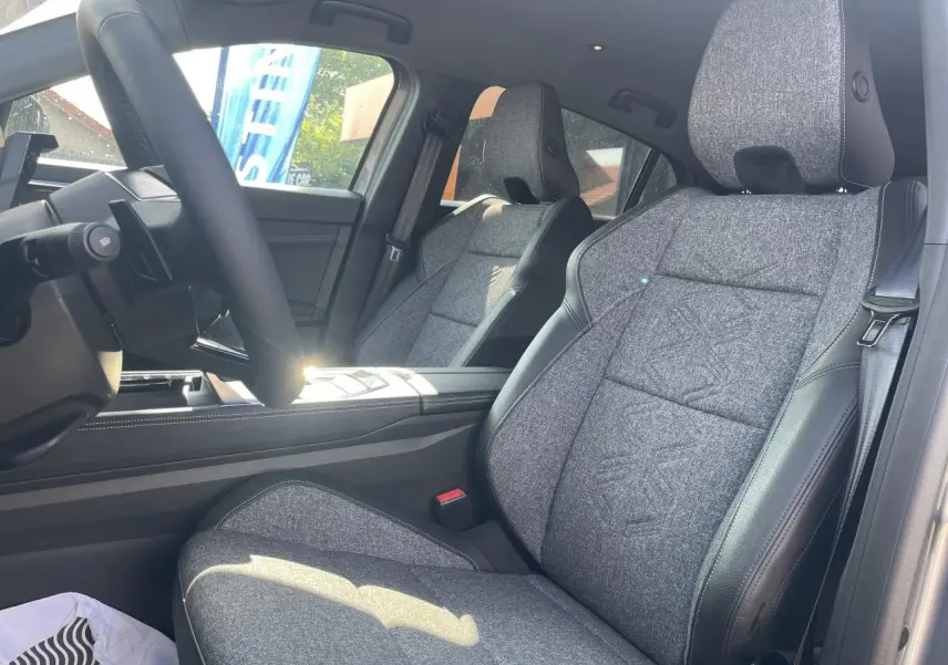 Intérieur côté conducteur de Renault Rafale 2025, sièges sport gris textile avec surpiqûres argent et volant textile refined.